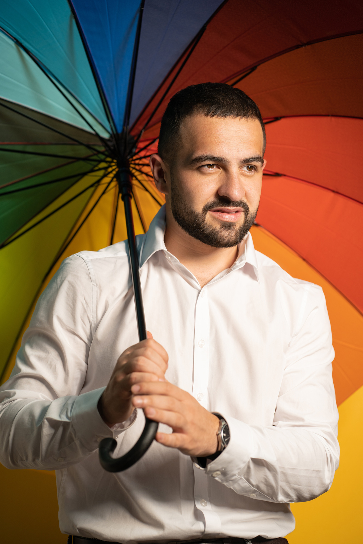 Man Holding a Rainbow Umbrella